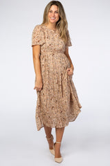 woman wearing a blush pink floral midi dress with short sleeves and pleated skirt