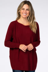 woman wearing a burgundy long sleeve sweater with a relaxed fit and round neckline