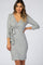 woman wearing a grey heathered v-neck maternity dress with a side tie and three-quarter sleeves