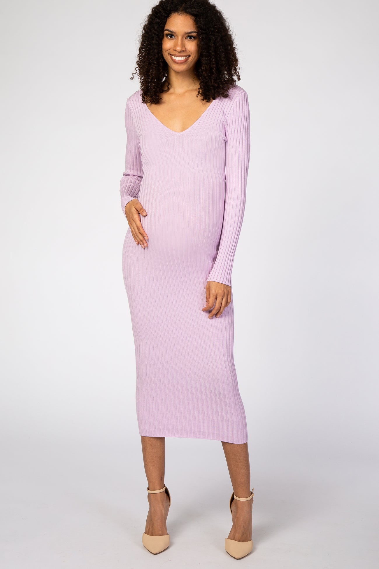 woman wearing a lavender ribbed long sleeve maternity dress and gently holding her baby bump