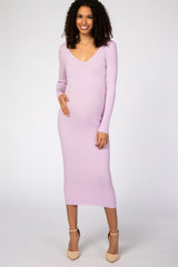 woman wearing a lavender ribbed long sleeve maternity dress and gently holding her baby bump