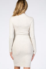 woman wearing a fitted beige long sleeve maternity dress, showing a smooth back view
