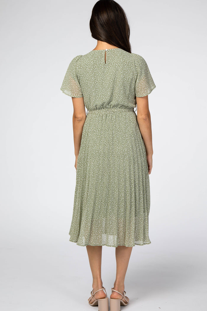 woman wearing a green floral midi dress with short sleeves and a cinched waist, shown from the back