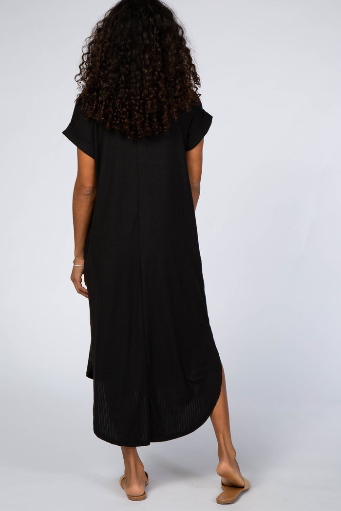 woman wearing a black oversized maxi dress with short sleeves and side slits, viewed from the back