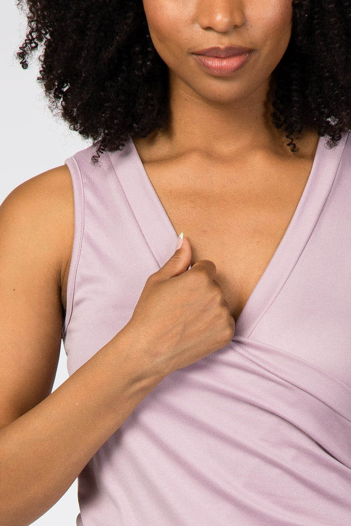 woman wearing a light purple sleeveless top with a v-neck and wrap style detail