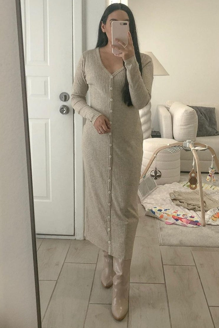 woman in beige ribbed button-down maxi dress and matching boots taking a mirror selfie in a living room