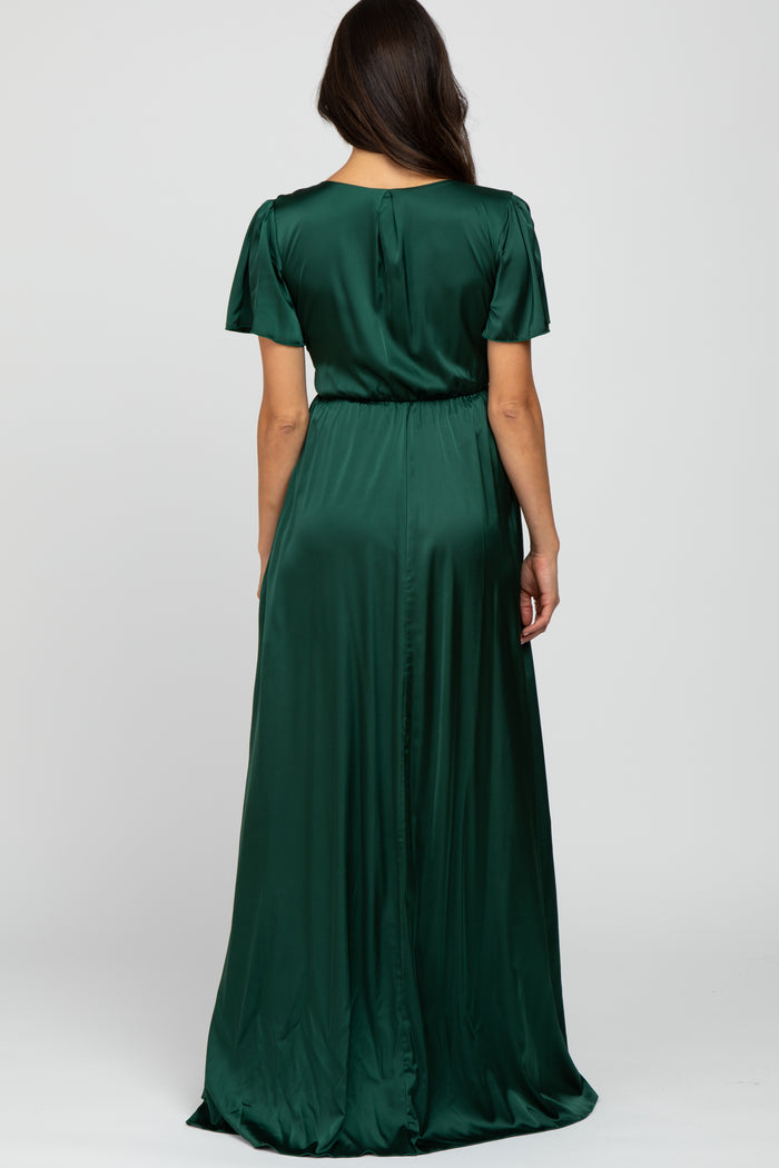 woman wearing a long green satin maxi dress with short sleeves and a cinched waist, viewed from the back