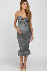 woman wearing a black and white striped maternity dress with a tie front, showcasing her baby bump and featuring a ruffled hem