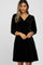 woman wearing a black velvet wrap dress with three-quarter sleeves and a gathered waist
