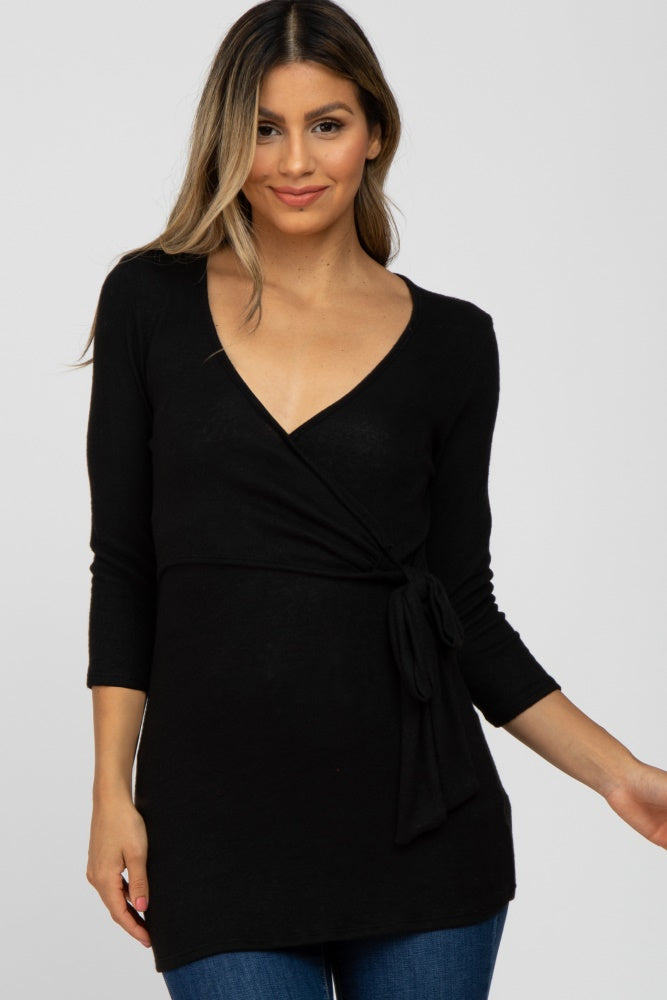 woman wearing a black long sleeve wrap top with a side tie and v-neckline
