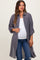 woman wearing a gray maternity button-up shirt over a white tank top and showing her baby bump with distressed jeans