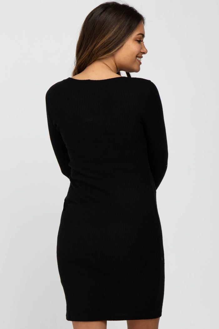 woman wearing a black ribbed long sleeve maternity dress, viewed from the back