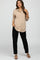 woman wearing a beige button-up maternity shirt and black maternity pants, showing her baby bump
