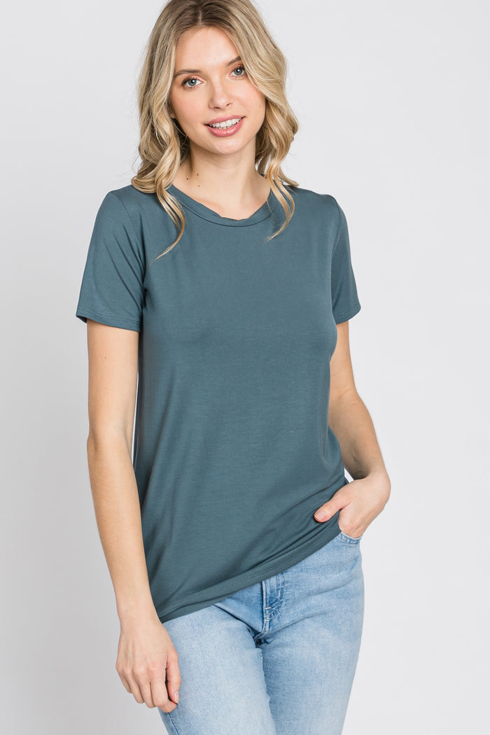 woman wearing a teal short sleeve t-shirt paired with light blue jeans