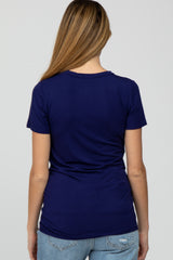 woman wearing a navy blue maternity t-shirt, showing the back view, paired with light blue jeans