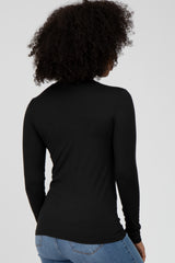 woman wearing a fitted black long sleeve top, viewed from the back, paired with light blue jeans
