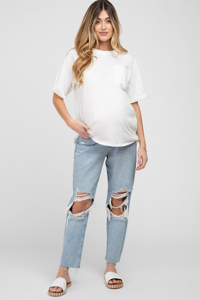 woman wearing a white short sleeve maternity t-shirt with a pocket and distressed light blue maternity jeans, showing a baby bump