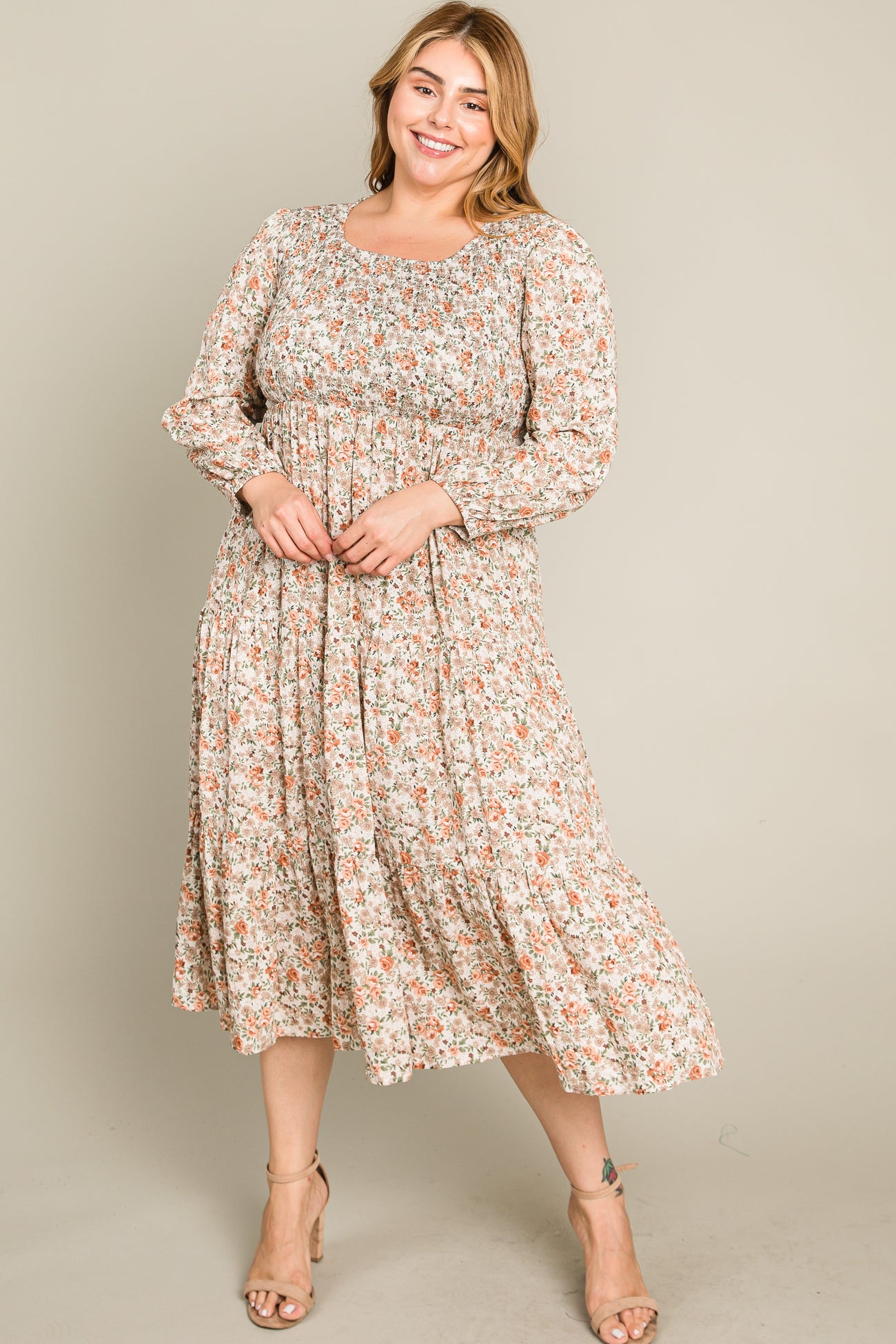woman wearing a floral print plus size maxi dress with long sleeves and a flowy silhouette