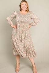 woman wearing a floral plus size midi dress with long sleeves and a ruffled hem, posing happily