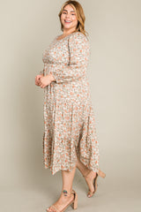 woman wearing a floral plus size midi dress with long sleeves and a tiered skirt, smiling while standing sideways
