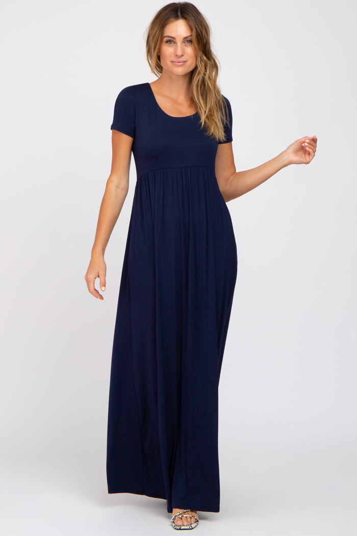 Woman wearing a navy blue short sleeve maternity maxi dress with a scoop neckline and empire waist