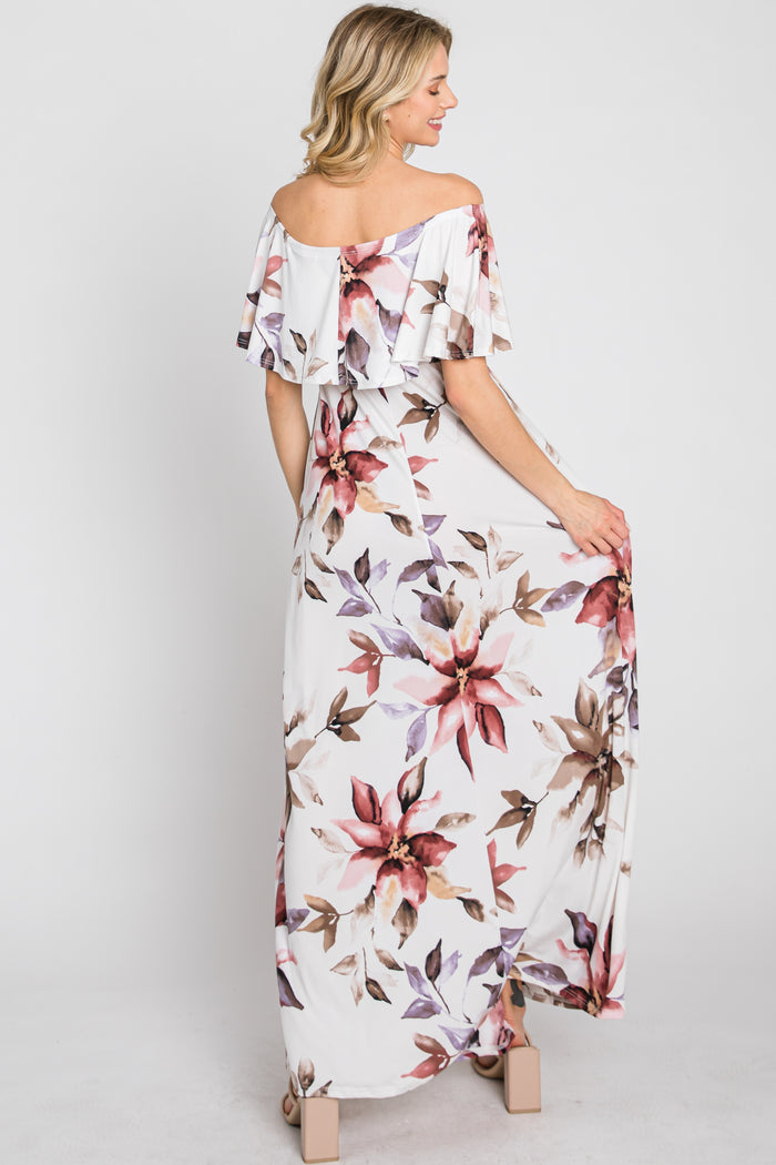 woman wearing a white floral off-the-shoulder maxi dress with ruffle details, showing the back view