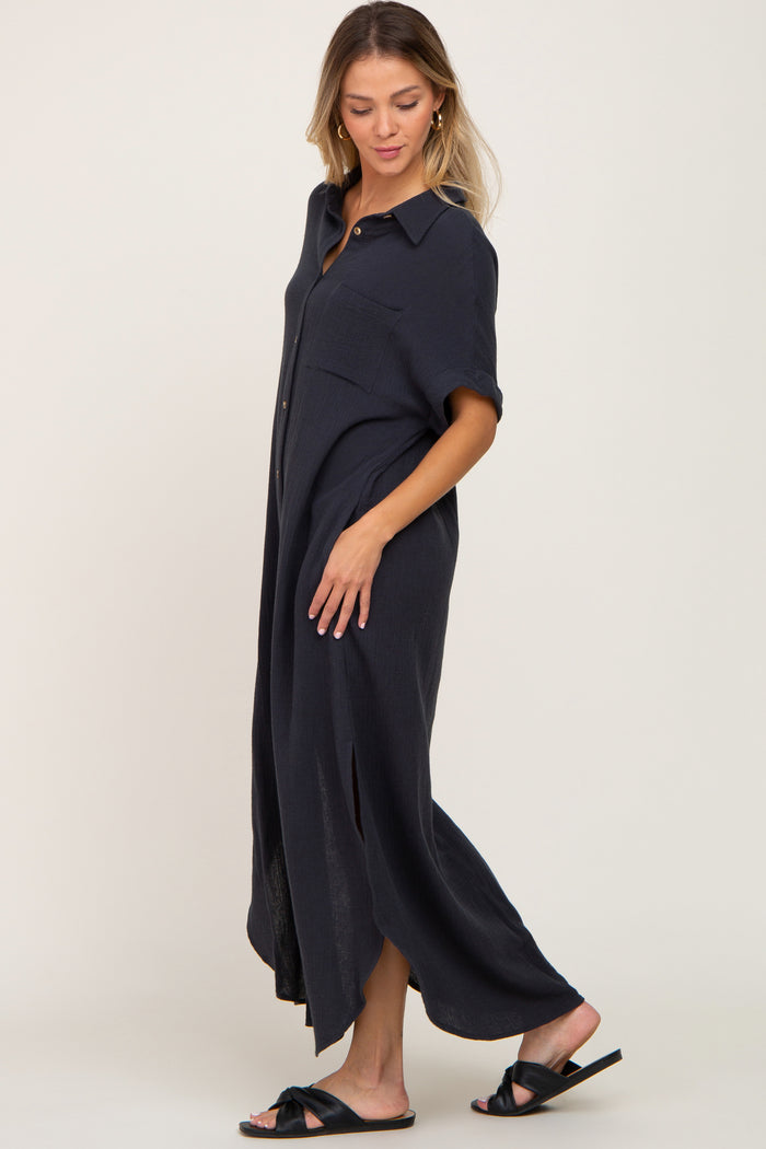 woman wearing a navy blue button-up maxi dress with short sleeves and side slits, standing in profile