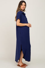 woman wearing a navy blue button-up maternity dress with short sleeves and side slits, showing her baby bump