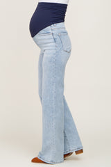 woman wearing light blue maternity flared jeans and a navy top, showing her baby bump