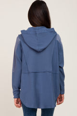 woman wearing a navy blue hooded oversized top with a relaxed fit and contrast stitching details