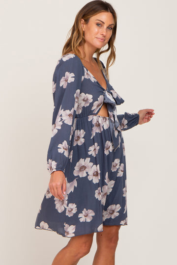 woman wearing a navy floral dress with a tied front and cut-out details