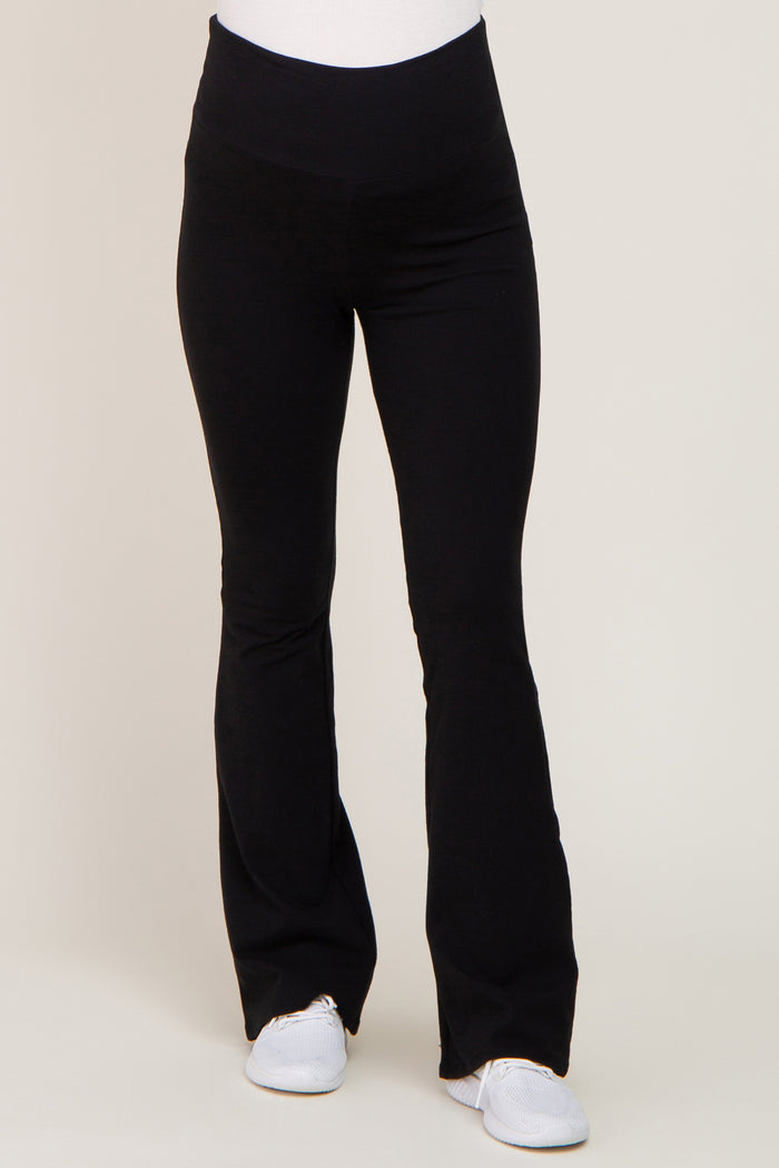 woman wearing black maternity leggings with a flared hem and a stretchy waistband