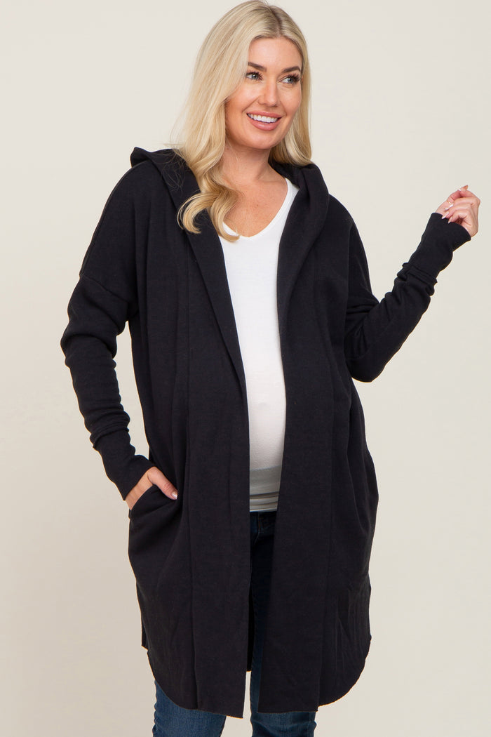 woman wearing a black maternity hoodie cardigan and showing her baby bump