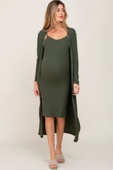 woman wearing an olive green maternity dress with a long cardigan and showing her baby bump
