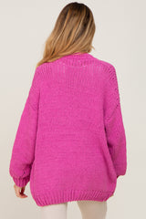 woman wearing a bright pink oversized knit maternity sweater, view from the back