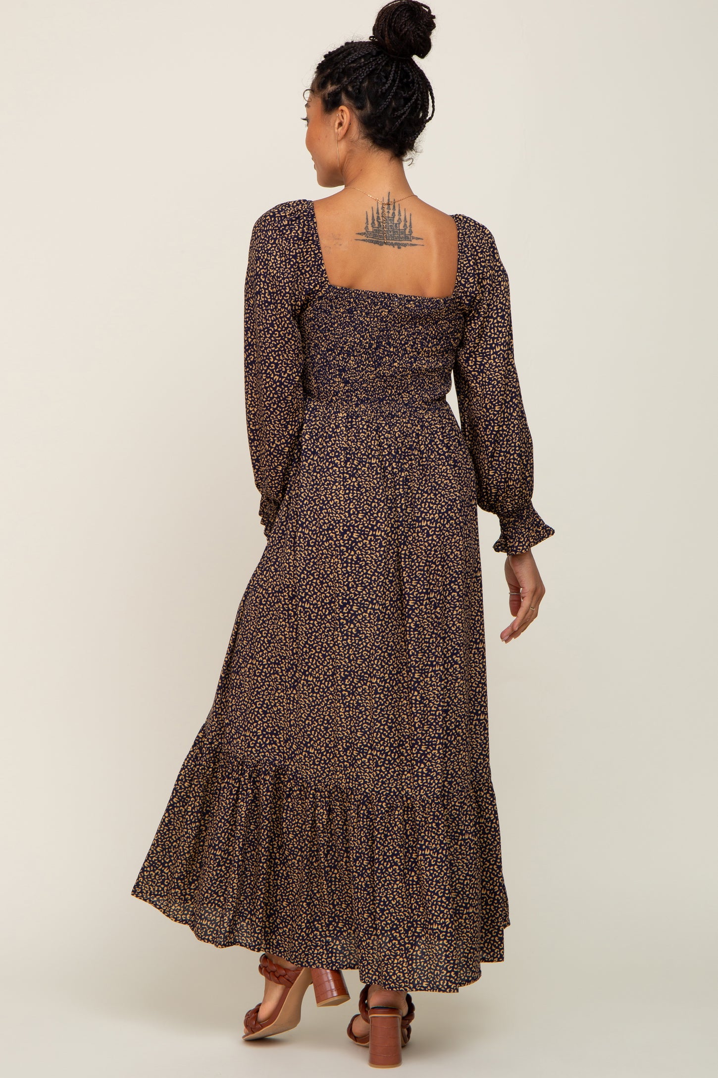 woman wearing a long-sleeve floral maxi dress with a smocked bodice and tiered skirt, seen from the back