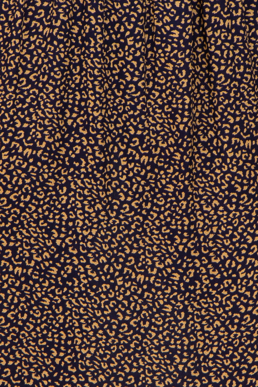 navy blue fabric with a tan abstract leopard print pattern