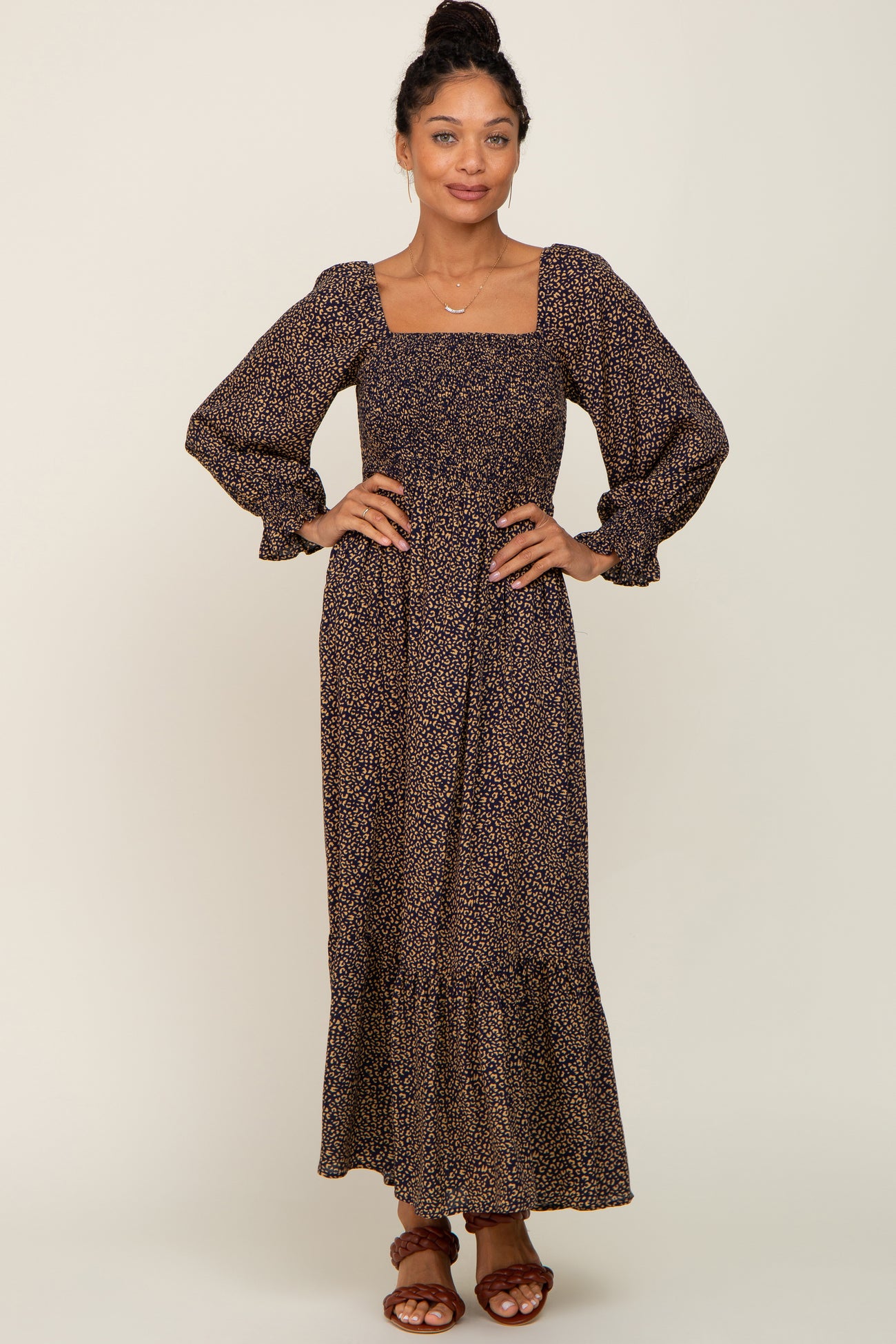 woman wearing a long sleeve maxi dress with a square neckline and floral print in dark tones