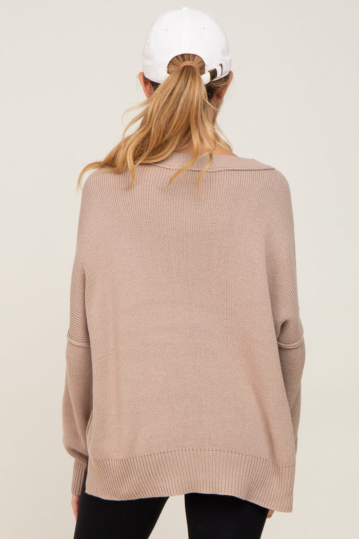 woman wearing a tan oversized maternity sweater with a relaxed fit and long sleeves, seen from the back