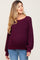 woman wearing a burgundy chunky knit maternity sweater with a relaxed fit and a visible baby bump