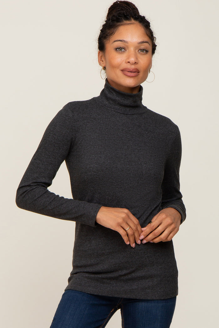 woman wearing a charcoal grey ribbed long sleeve turtleneck top and blue jeans