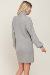 woman wearing a cozy gray ribbed sweater dress with a high neck and long sleeves, shown from the back