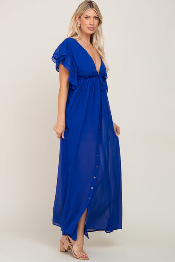woman wearing a blue maxi dress with ruffled sleeves and a deep v-neckline, showing a button detail down the front