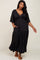 woman wearing a black tiered maxi dress with a deep v-neck and short sleeves, featuring pockets