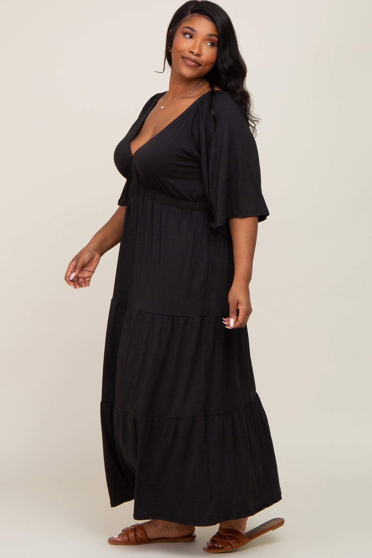 woman wearing a black tiered maxi dress with a v-neck and flutter sleeves