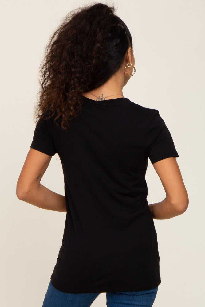 woman wearing a black short sleeve t-shirt, viewed from the back with curly hair styled down