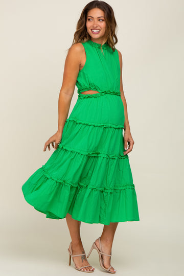 woman wearing a bright green sleeveless maternity dress with ruffle tiers and a cutout detail, showcasing her baby bump