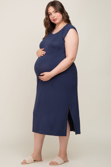 woman wearing a navy blue maternity plus dress with a side slit and a pocket, holding her baby bump