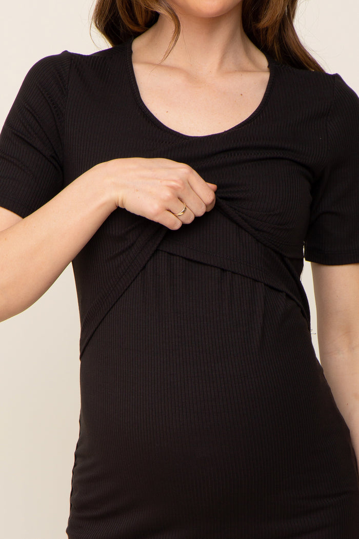 Woman wearing a black ribbed short sleeve maternity and nursing top with a lift-up access layer.