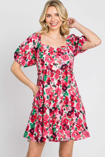 blonde woman wearing a pink and red floral print mini dress with puff sleeves and a square neckline